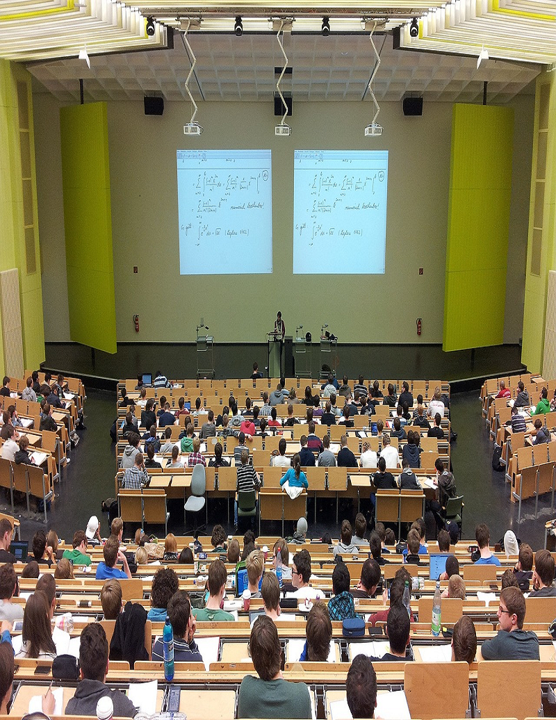 university A spacious lecture hall featuring a large projector screen at the front, ready for presentations and discussions.